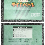 Two-panel image of a teal Japanese game box: front shows bold orange title たしざんでダイナバトル, back lists warnings and contents (15 cards, 20 support cards, 1 manual).